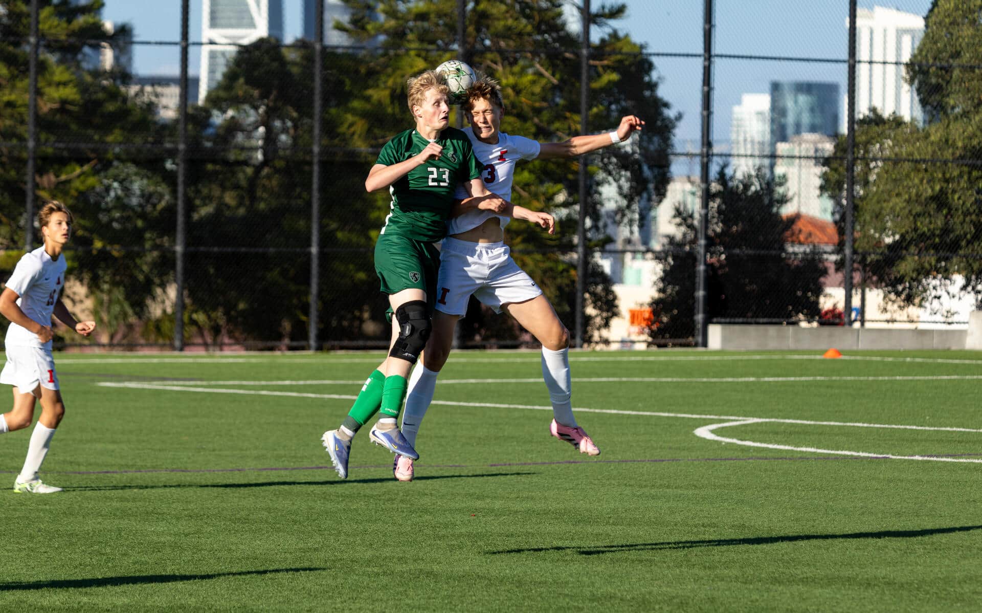 Two student athletes contesting a header during a soccer match